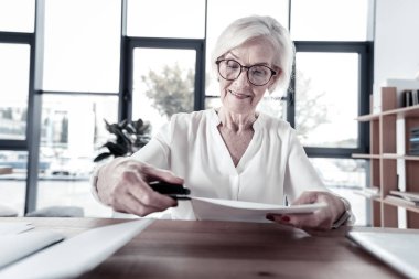 Neşeli kadın kağıtları katıldığınız için zımba kullanarak