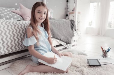 Katta oturan ve çizim neşeli kız