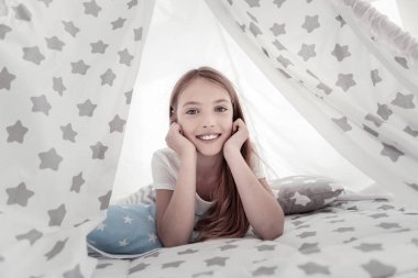 Neşeli kız yatakta yatarken gülümseyen