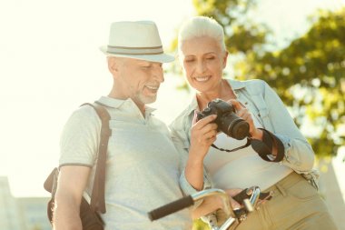 Bir fotoğraf makinesi tutan olumlu yaşlı kadın