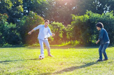 Neşeli baba ve oğul birlikte futbol oynamaya