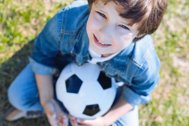 Sevimli çocuk futbol oynadıktan sonra gülümseyerek topu ile