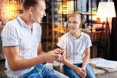Neşeli adam bir smartphone oğlu müzik süre tutan