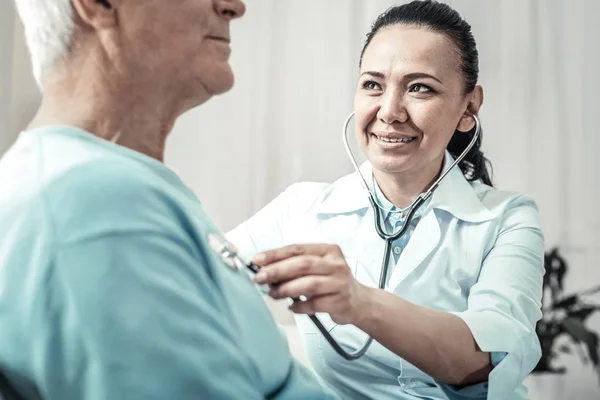Vrolijke mooie arts met behulp van de stethoscoop en glimlachen. — Stockfoto