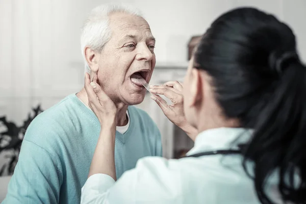 Grå åldern man efter undersökning och sitter mittemot sjuksköterskan. — Stockfoto