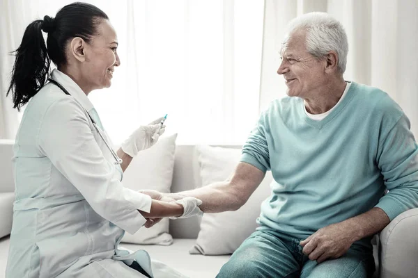 Vrolijke schattig verpleegkundige glimlachend en het maken van injectie. — Stockfoto