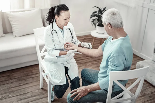 Concentrated serious nurse keeping calm and making injection. — Stock Photo, Image