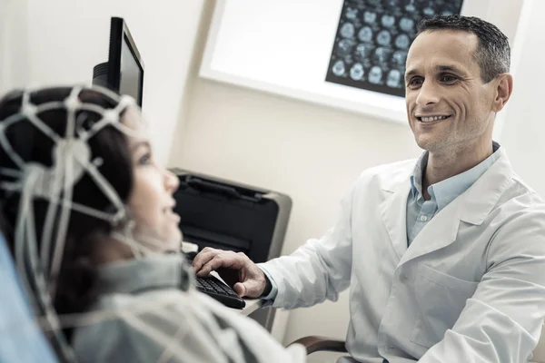 Fröhlich fröhlicher Arzt schaut seinen Patienten an — Stockfoto