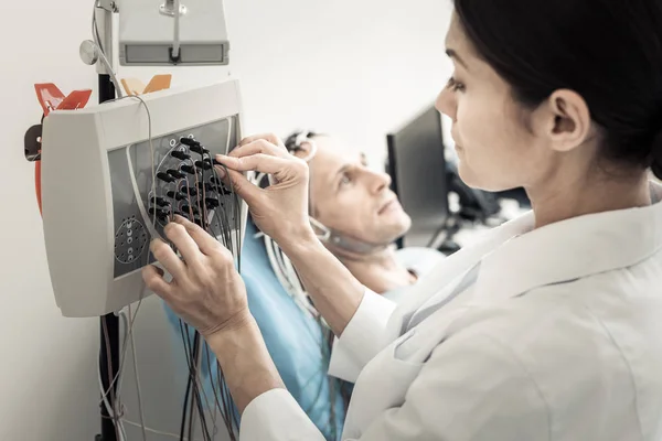 Professioneller netter Arzt beim Einrichten des Elektroenzephalographen — Stockfoto
