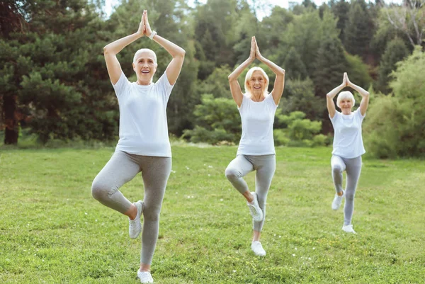 Mulheres idosas alegres praticam ioga — Fotografia de Stock
