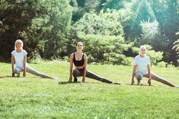 Mulheres alegres positivas se exercitando ao ar livre — Fotografia de Stock