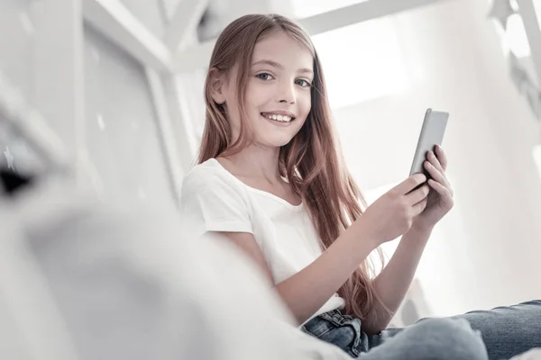 Sonriente chica de pelo largo con su teléfono — Foto de Stock