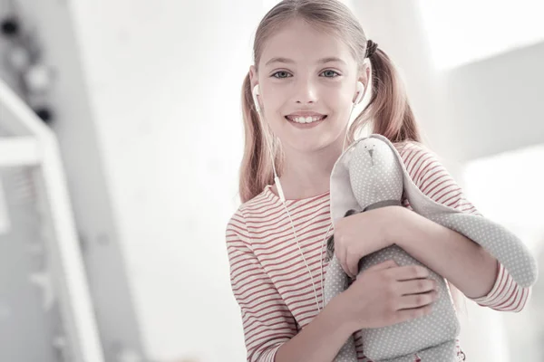 Menina sorridente feliz segurando seu brinquedo — Fotografia de Stock