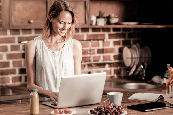 Привлекательная веселая женщина, работающая над ноутбуком — стоковое фото