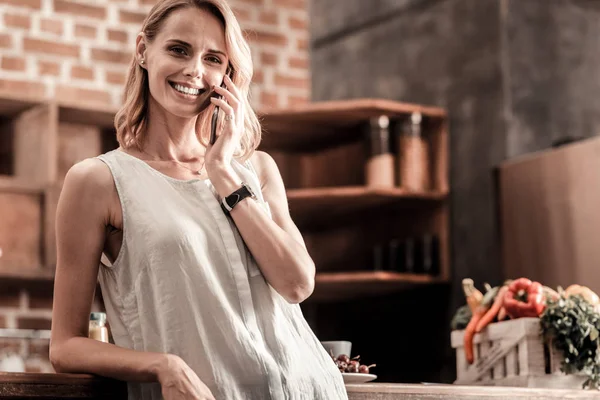 Deliziosa donna positiva avendo una conversazione telefonica — Foto Stock