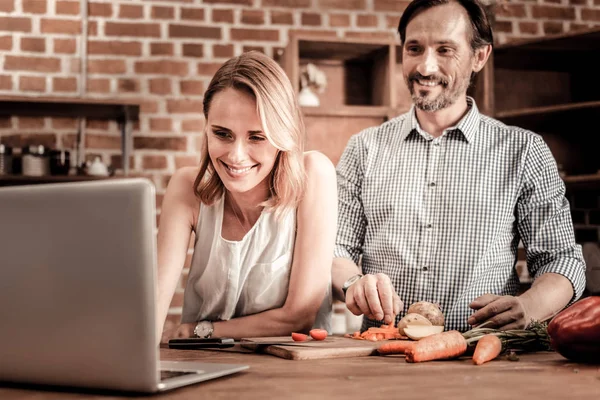 Trevlig glad kvinna som tittar på den bärbara skärmen — Stockfoto