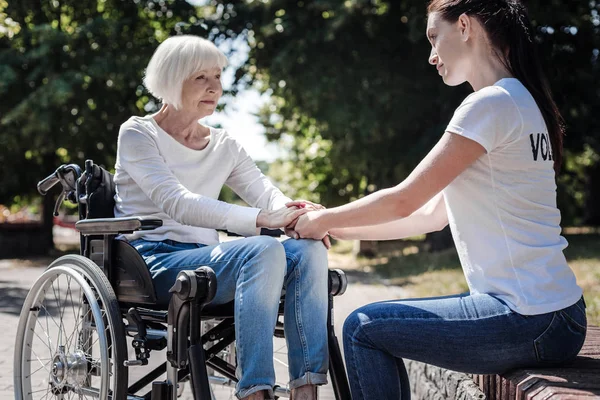 Positiv äldre kvinna som håller händerna volontärer — Stockfoto