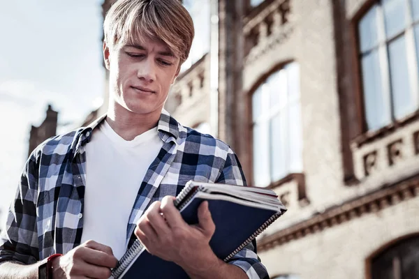 Charmant homme sérieux regardant ses livres — Photo