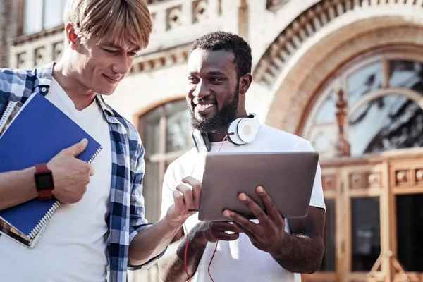 Positive college student looking at the tablet — Stock Photo, Image