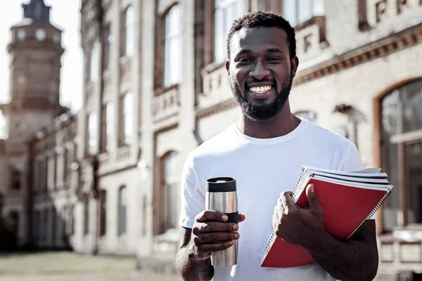 Nice cheerful man holding a thermo cup — Stock Photo, Image