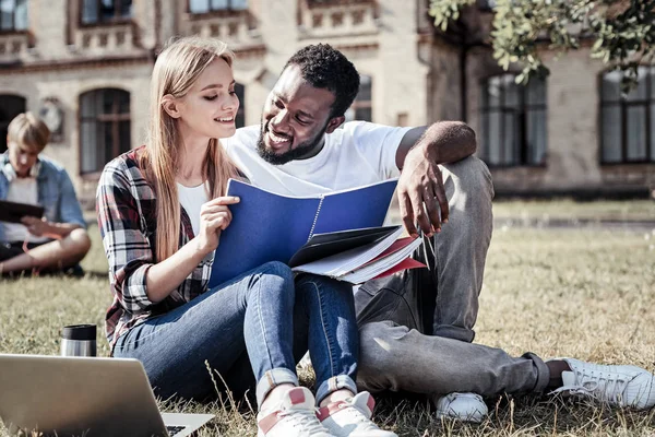 Joyeux étudiants intelligents lisant des notes de cours — Photo