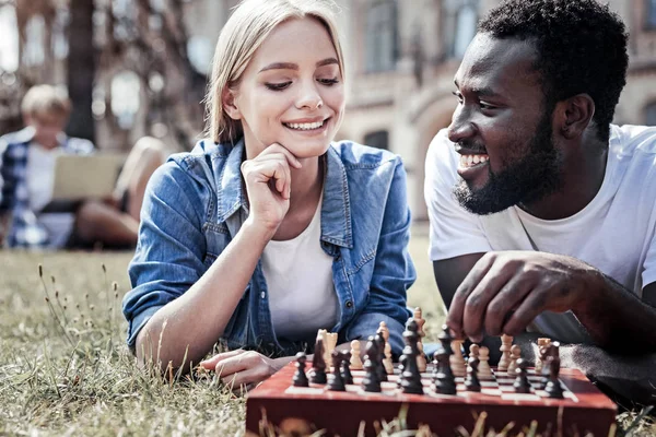 チェス盤を見て喜んでいる思いやりのある女性 — ストック写真