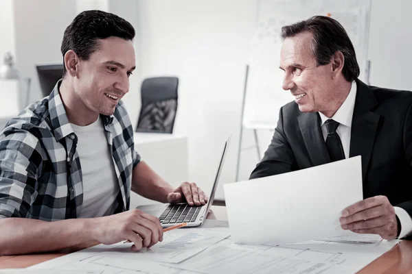 Jeune homme positif regardant le document — Photo