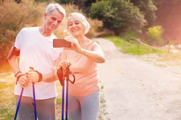 휴대 전화를 들고 긍정적인 노인 가족 — 스톡 사진