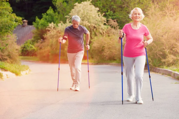 Coppia anziana utilizzando bastoni da passeggio — Foto Stock
