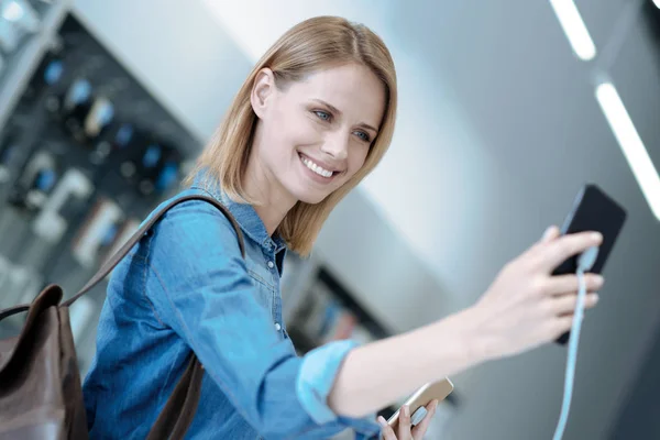 Glad flicka poserar på kamera av telefon — Stockfoto