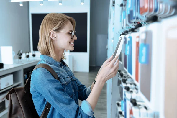 Attentive girl choosing accessories for her gadget — Stock Photo, Image