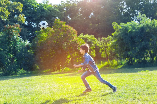 Ativo adolescente menino jogando futebol ao ar livre — Fotografia de Stock