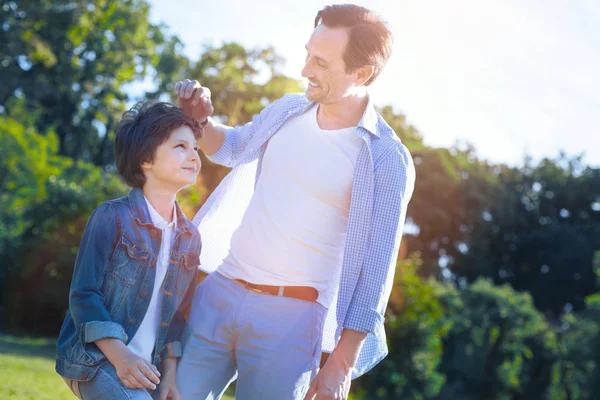 Fröhlicher Vater und Sohn lächeln einander zu — Stockfoto