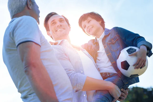 Fröhliche Familie diskutiert nach dem Spielen im Freien über Fußball — Stockfoto