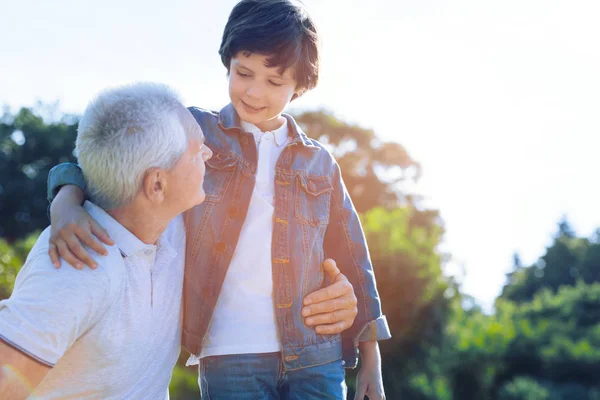 Lindo niño preadolescente hablando con el abuelo cariñoso al aire libre —  Fotos de Stock