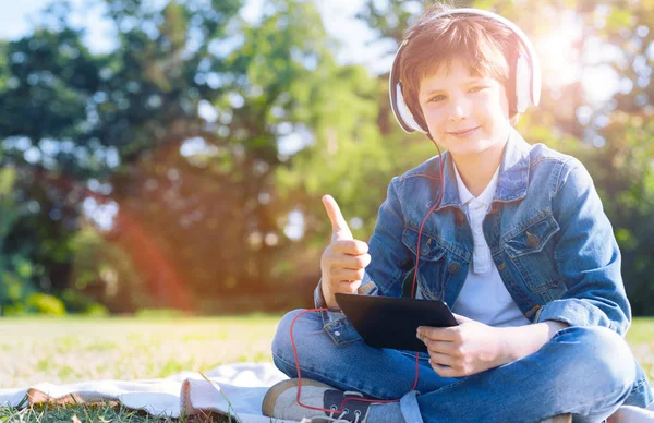 Wesoły dzieciak przekopywanie się podczas słuchania muzyki — Zdjęcie stockowe