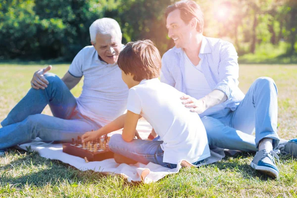 Vater und Opa bringen kleinem Jungen Schach bei — Stockfoto