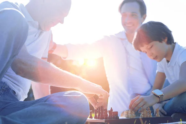 Friendly family playing chess together — Stock Photo, Image