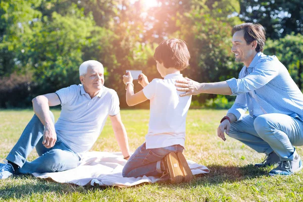 Familia multigeneracional divirtiéndose y tomando fotos al aire libre —  Fotos de Stock