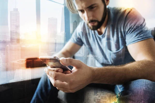 Serious young man looking at the screen and feeling upset — Stock Photo, Image