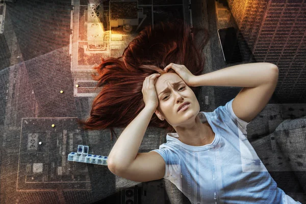 Ausdrucksstarke junge Frau berührt ihren Kopf, während sie unter Schmerzen leidet — Stockfoto