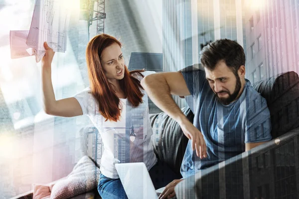 Furious young woman throwing documents into her boyfriend — Stock Photo, Image