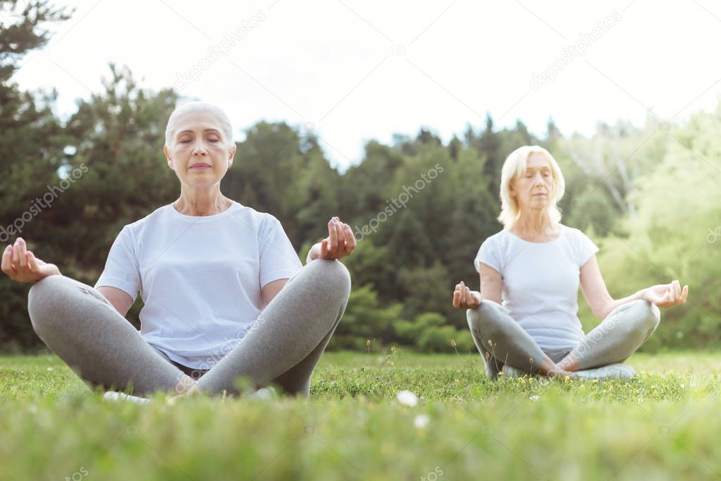 Nice elderly women sitting in the lotus pose