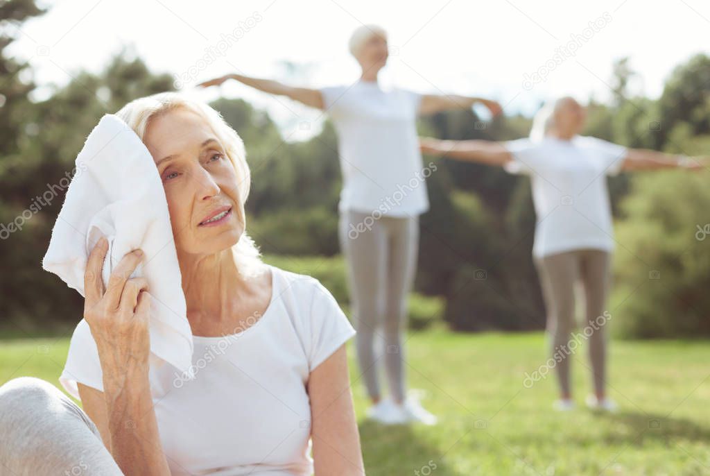 Pleasant tired woman holding a towel
