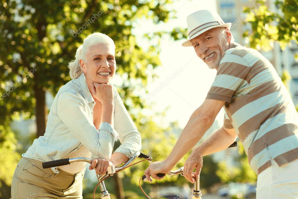 Positive aged couple riding bikes together
