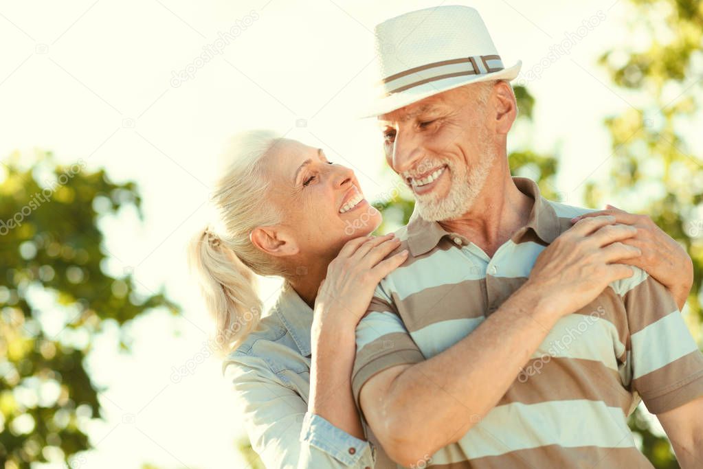 Joyful nice woman standing behind her husband