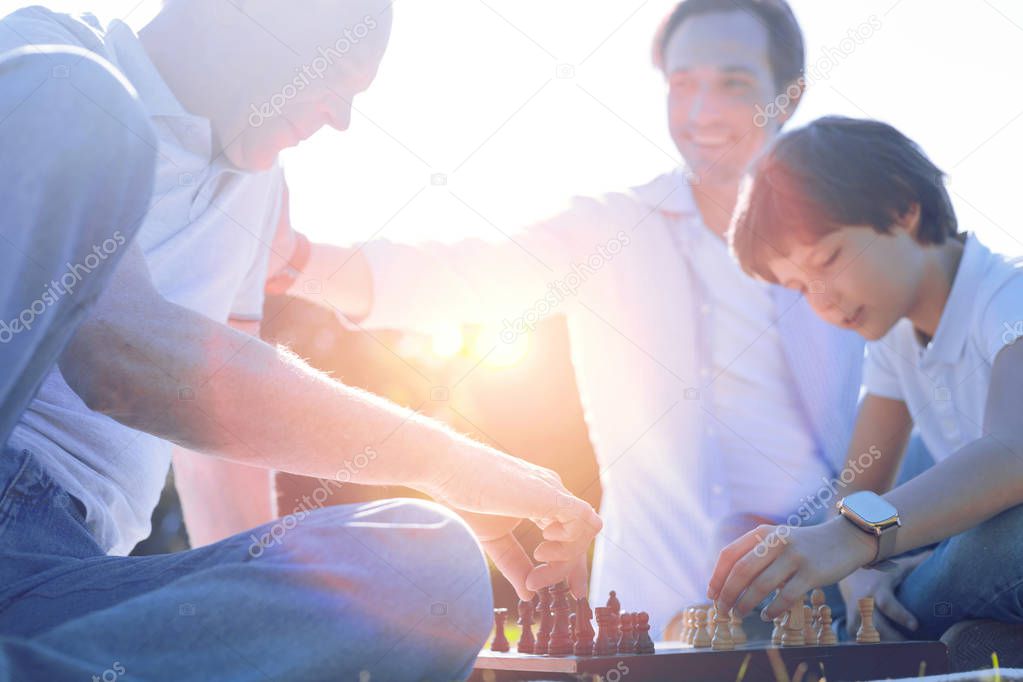 Friendly family playing chess together