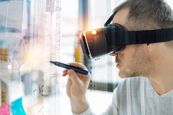Hombre serio en gafas de realidad virtual mirando tranquilo y sosteniendo un marcador —  Fotos de Stock