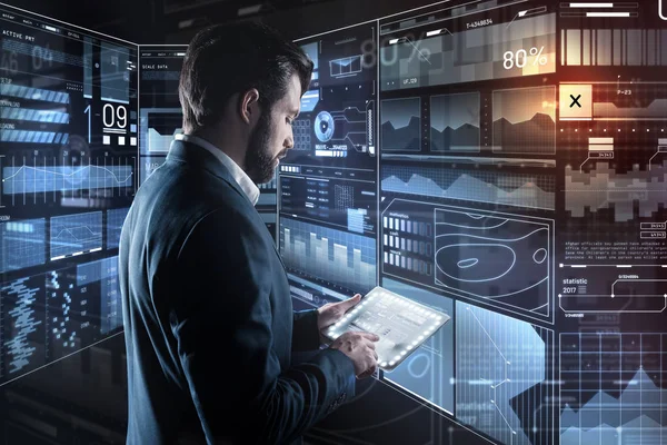 Concentrated man looking at his tablet while working alone — Stock Photo, Image