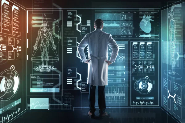 Lugn allvarliga läkare känner sig intresserad av medan du tittar på futuristiska enheten — Stockfoto